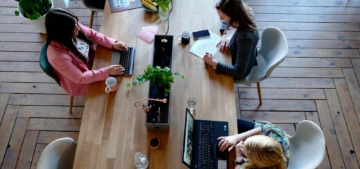 Overhead view of diverse women professionals working in a modern office setting, fostering collaboration and teamwork.